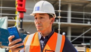 Chef d'équipe BTP utilisant l'IA sur son smartphone en chantier